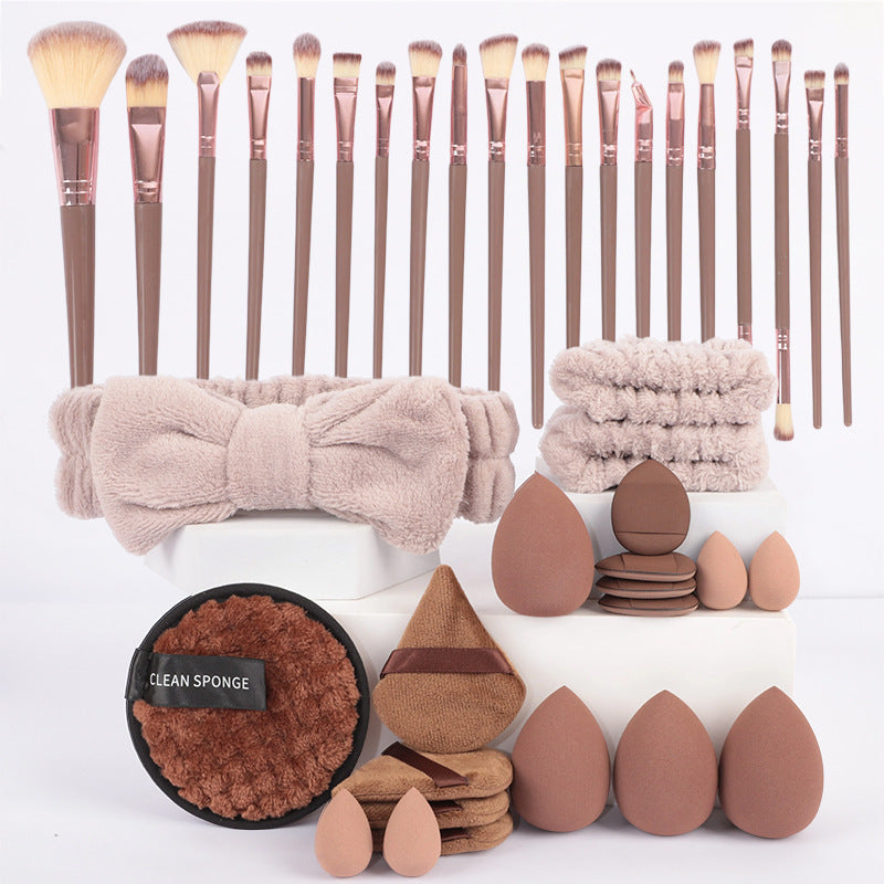 Set of makeup brushes, a bow, and various beauty tools on a white background