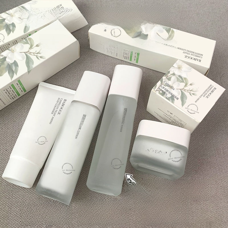 Skincare products including bottles and a jar on a gray surface with boxes in the background.